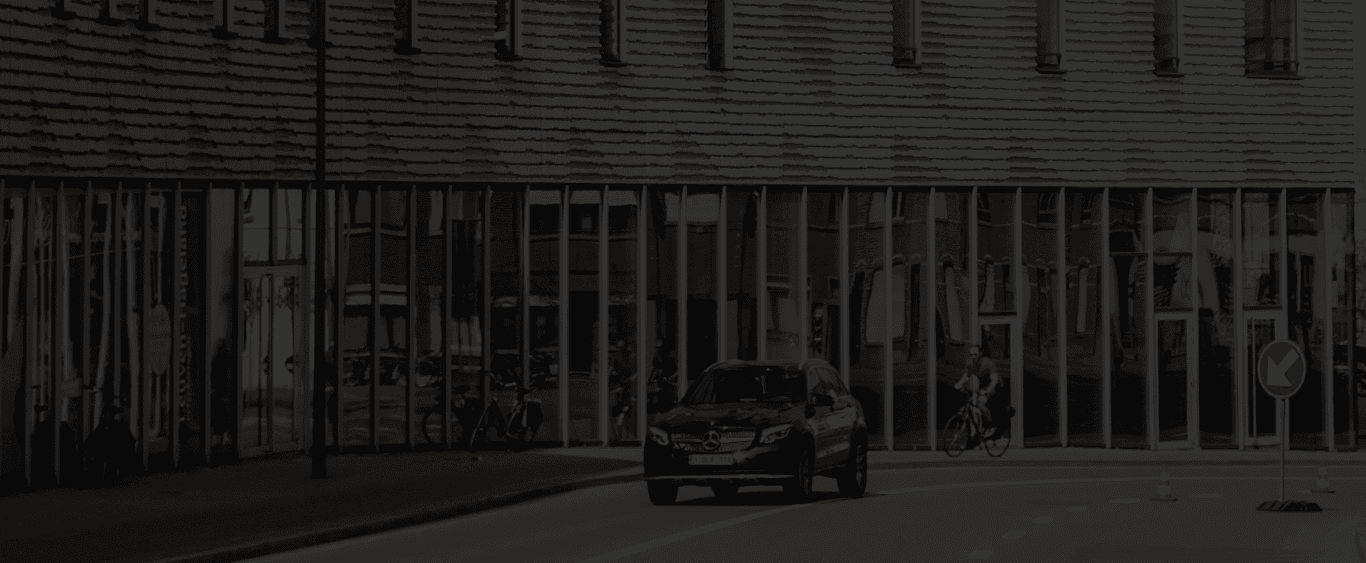 A modern car driving on a city street, representing corporate fleets managed with the TAXO vehicle tax calculator.